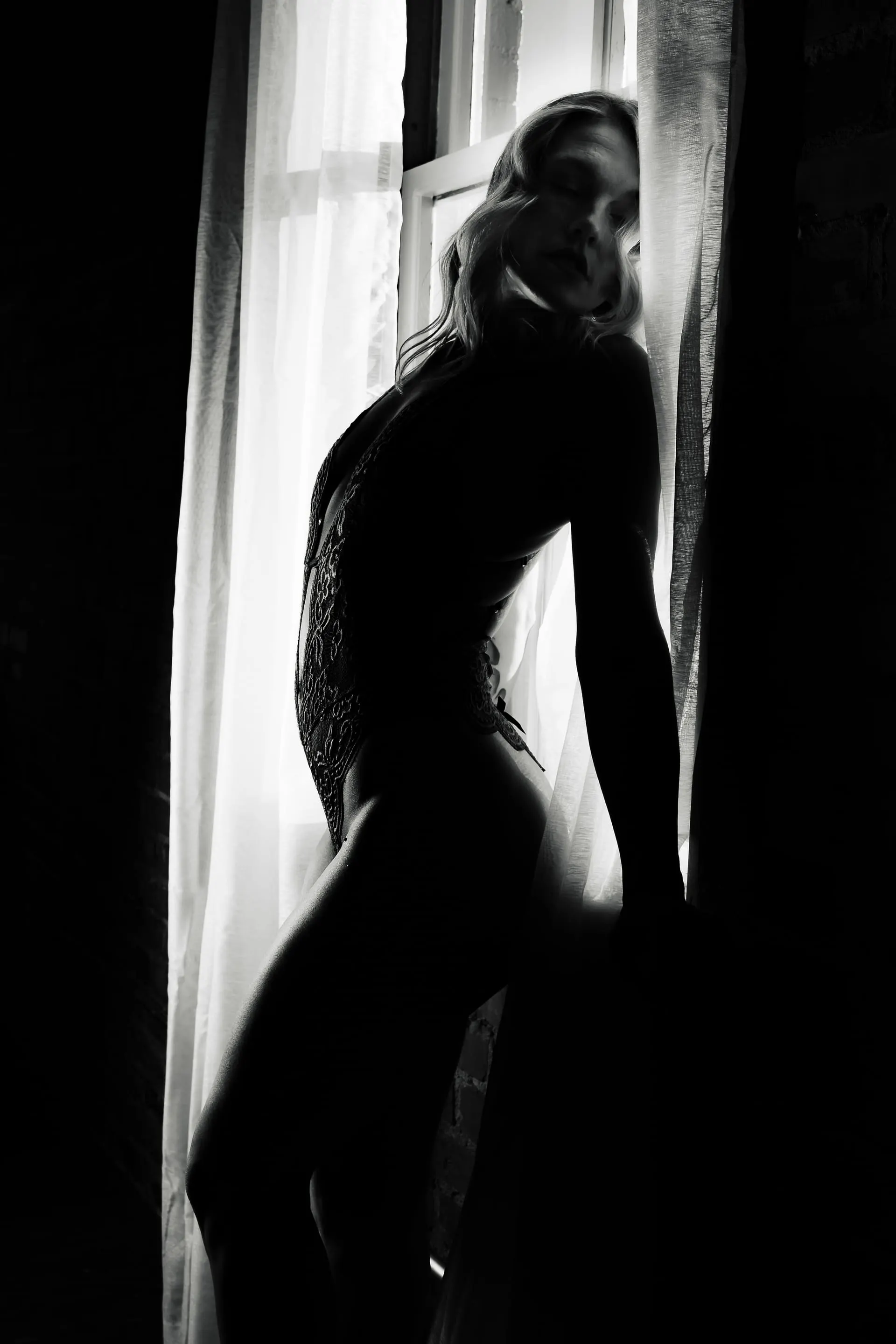 Black and white boudoir silhouette in window light