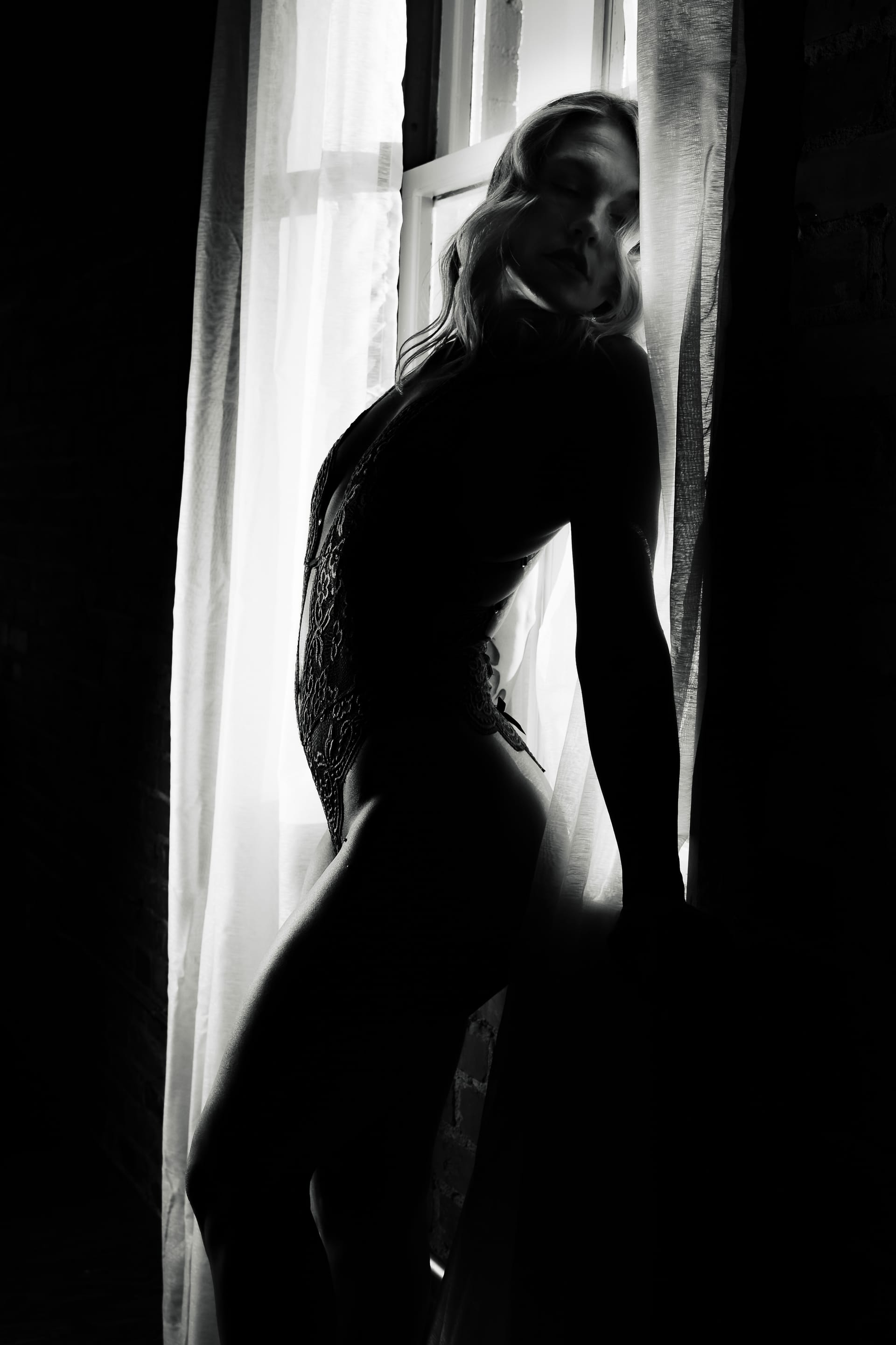 Black and white boudoir silhouette in window light